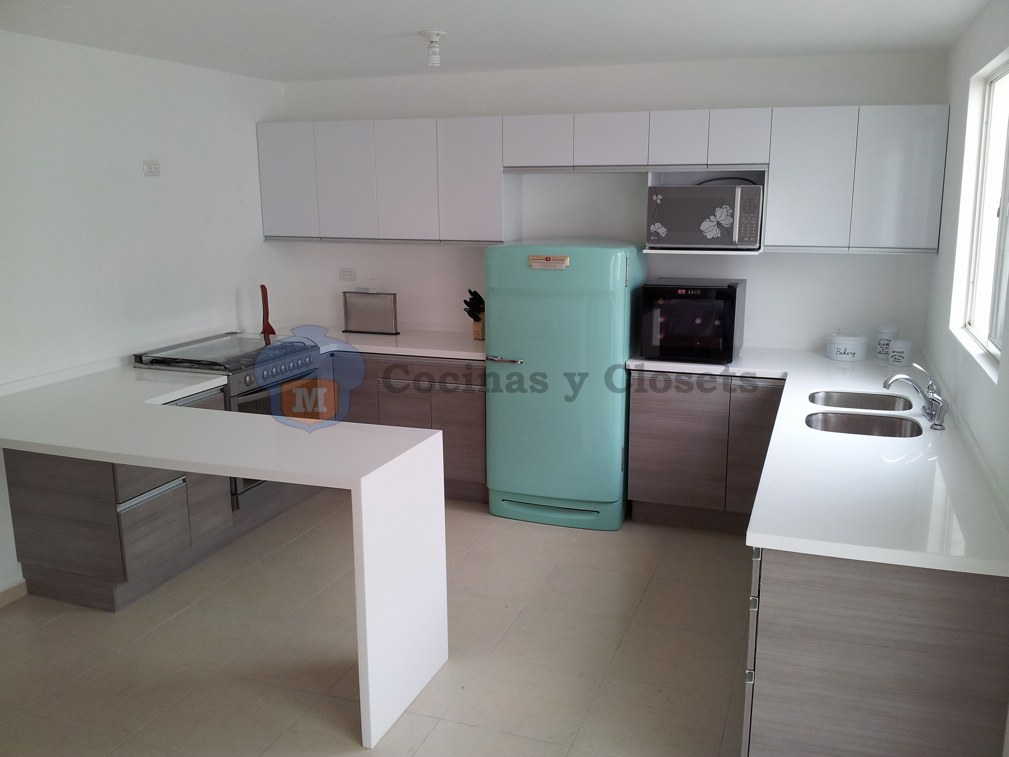 Cocina en U con cubierta en Corian con barra